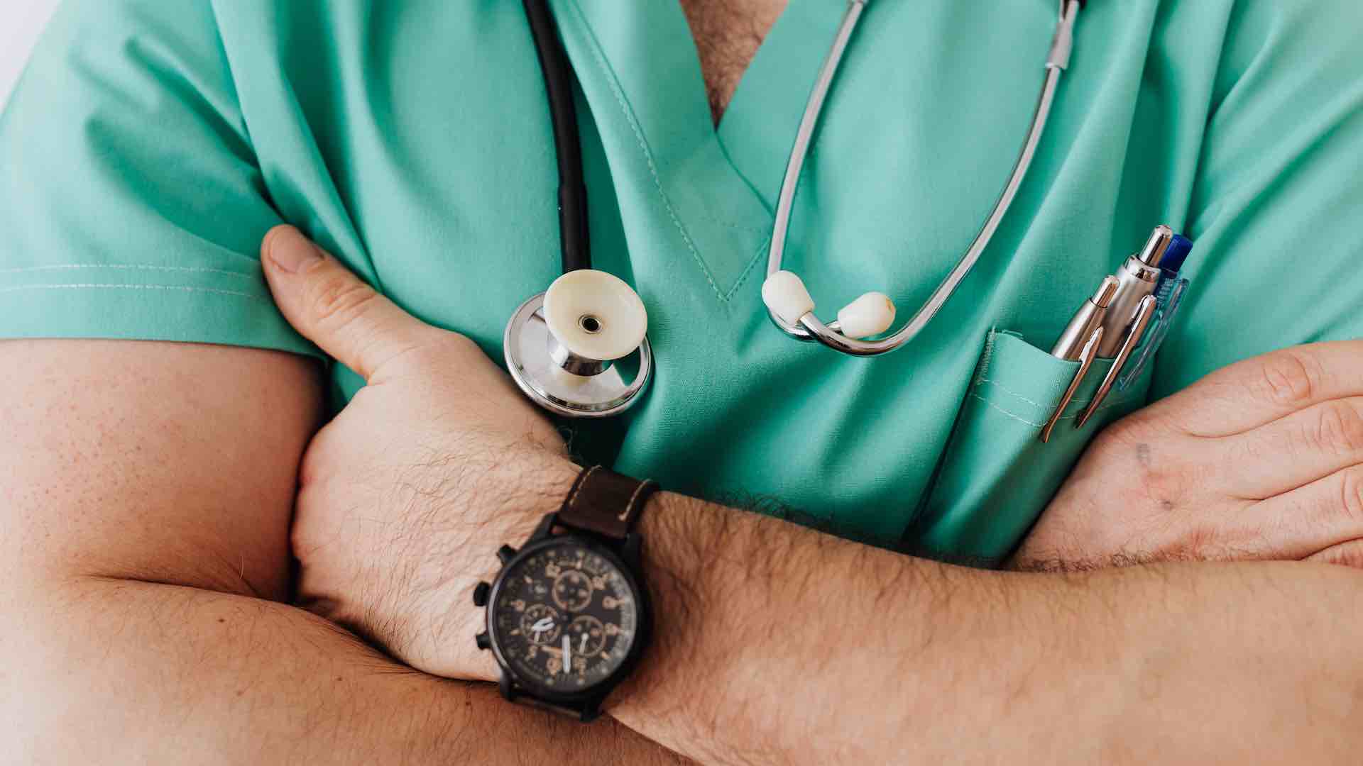 a doctor with an stethoscope and crossed arms.